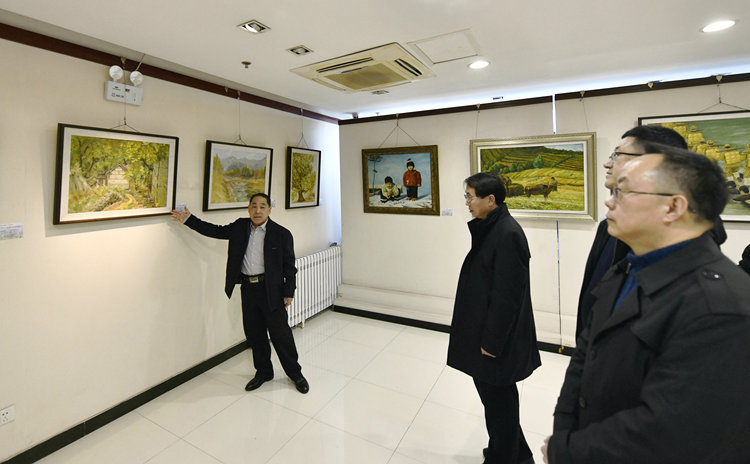 迁安市“万象于心 故乡情真”滕国富绘画作品展开展_fororder_滕国富（左一）向现场观众讲解油画作品。梁玉水摄