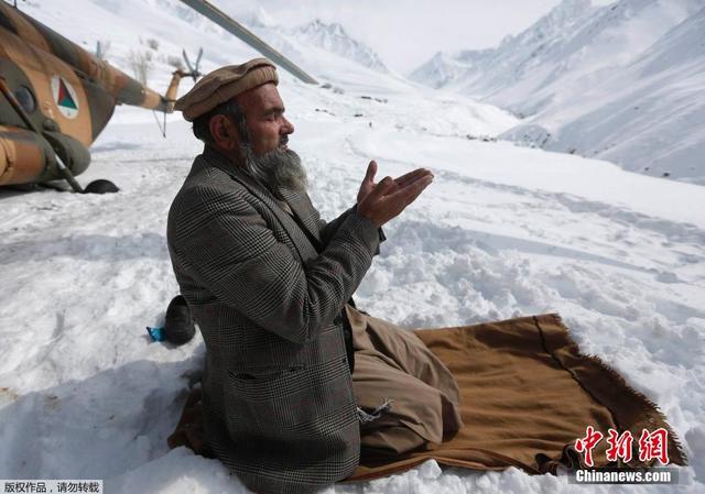 阿富汗雪崩幸存者搬运救援物资 跪雪地祈祷