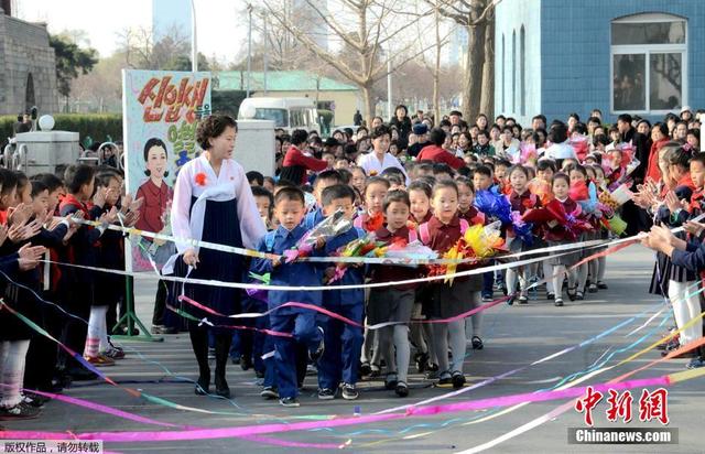 朝鲜学生手捧花束佩戴大红花迎接新学期