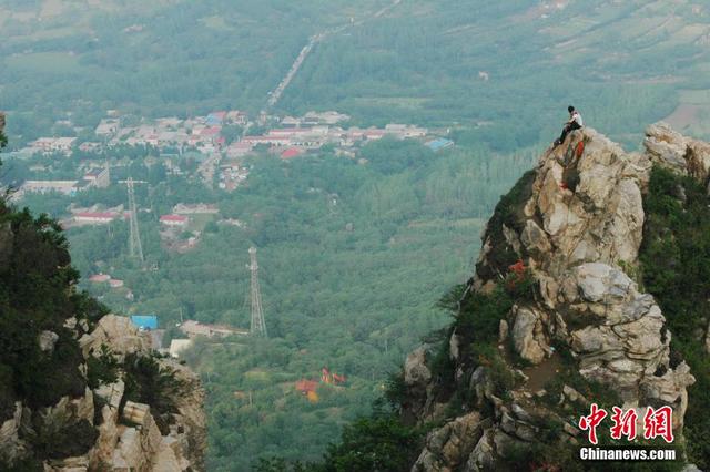 郑州景区游客爬百米悬崖绝壁 拍照留影