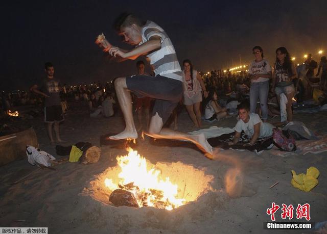 西班牙庆祝圣胡安仲夏节 民众光脚跨篝火