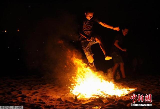 西班牙庆祝圣胡安仲夏节 民众光脚跨篝火