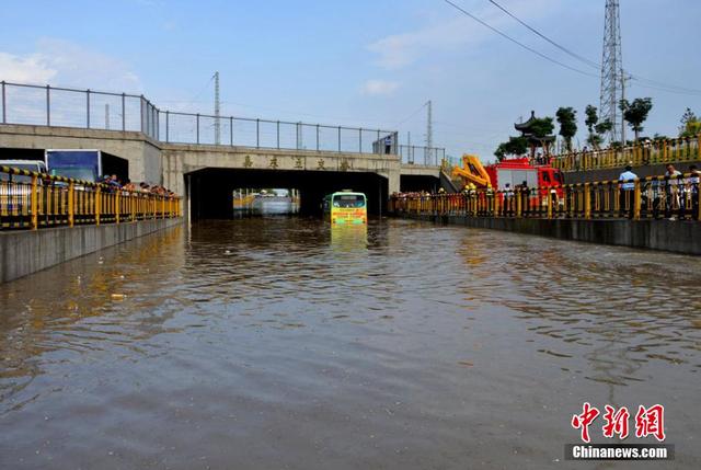 甘肃一公交车被淹路中间 乘客爬消防梯获救