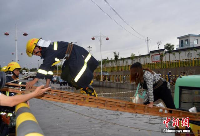 甘肃一公交车被淹路中间 乘客爬消防梯获救