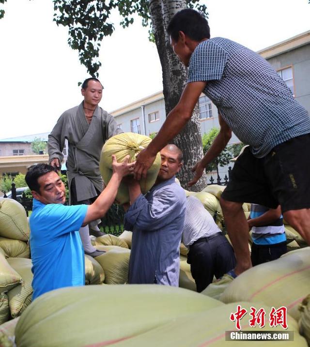 少林寺僧人自种粮食送灾民 肩扛麻袋健步如飞