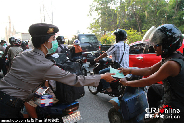 印尼森林火灾致空气污染 女警街头发放免费口罩