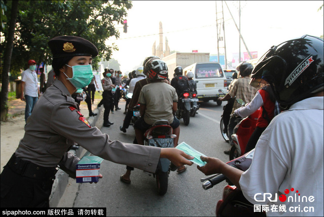 印尼森林火灾致空气污染 女警街头发放免费口罩