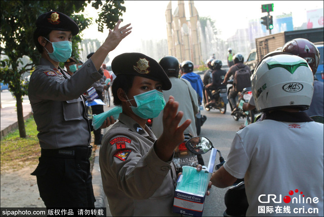 印尼森林火灾致空气污染 女警街头发放免费口罩