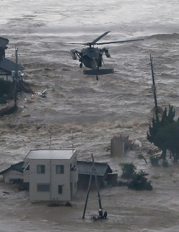 日本暴雨致上万房屋被淹 居民抱狗爬屋顶等救援