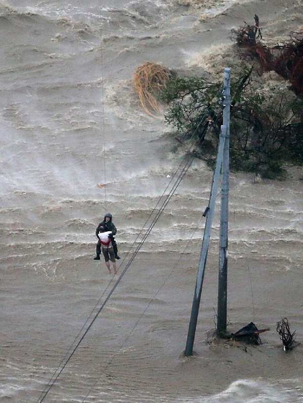 日本暴雨致上万房屋被淹 居民抱狗爬屋顶等救援