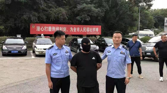 几代刑警接力追凶 鞍山一潜藏26载命案嫌疑人落网_fororder_潜逃26年的逃犯杨某（中）被抓捕归案 供图：鞍山市公安局_副本