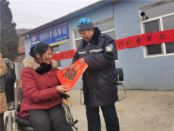 鞍山冯志国爱心团队走进大山送温暖 28年奉献换来爱的延续_fororder_冯志国为卜玉琴送福字 摄影 董楠楠