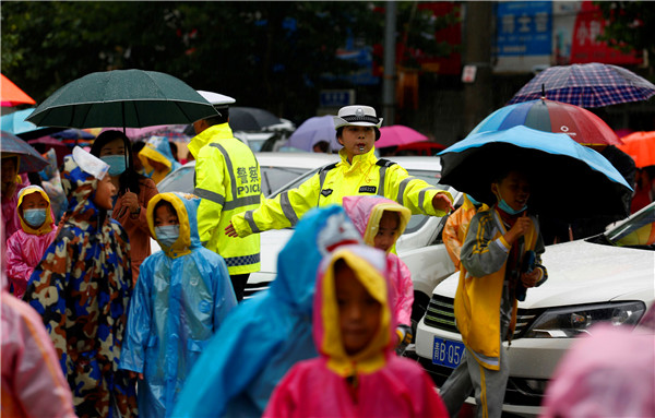 陕西渭南交警：坚守岗位 雨中护学