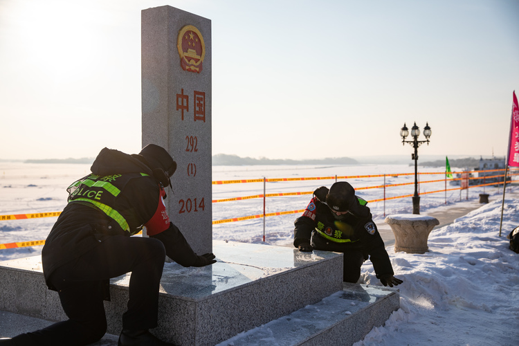 新春走基层 | “虎警官”携“黑虎”迎虎年_fororder_虎头边境派出所民警对界碑“292-（1）-2014”主桩上的积雪进行清理