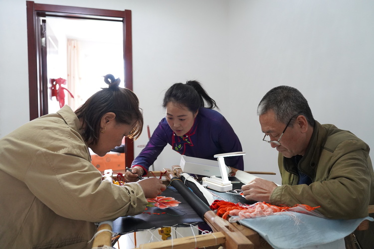 内蒙古科右中旗：蒙古族刺绣“绣”出民族团结之花_fororder_科右中旗蒙古族刺绣协会老师石梅给男绣工曹峰夫妻俩传授刺绣经验。.JPG