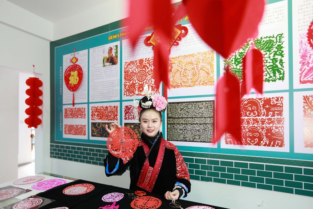 贵州剑河：生肖剪纸贺新年_fororder_1月17日，剪纸爱好者在剑河县华润希望小镇展示刚剪的窗花。（万文杰）