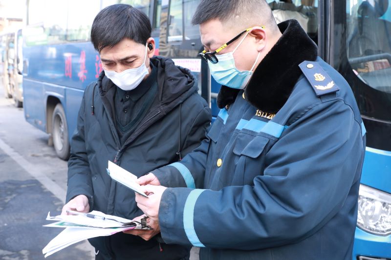 信阳市浉河区：春运保畅进行时_fororder_宋飞（右）正在查验班车的出站手续.JPG