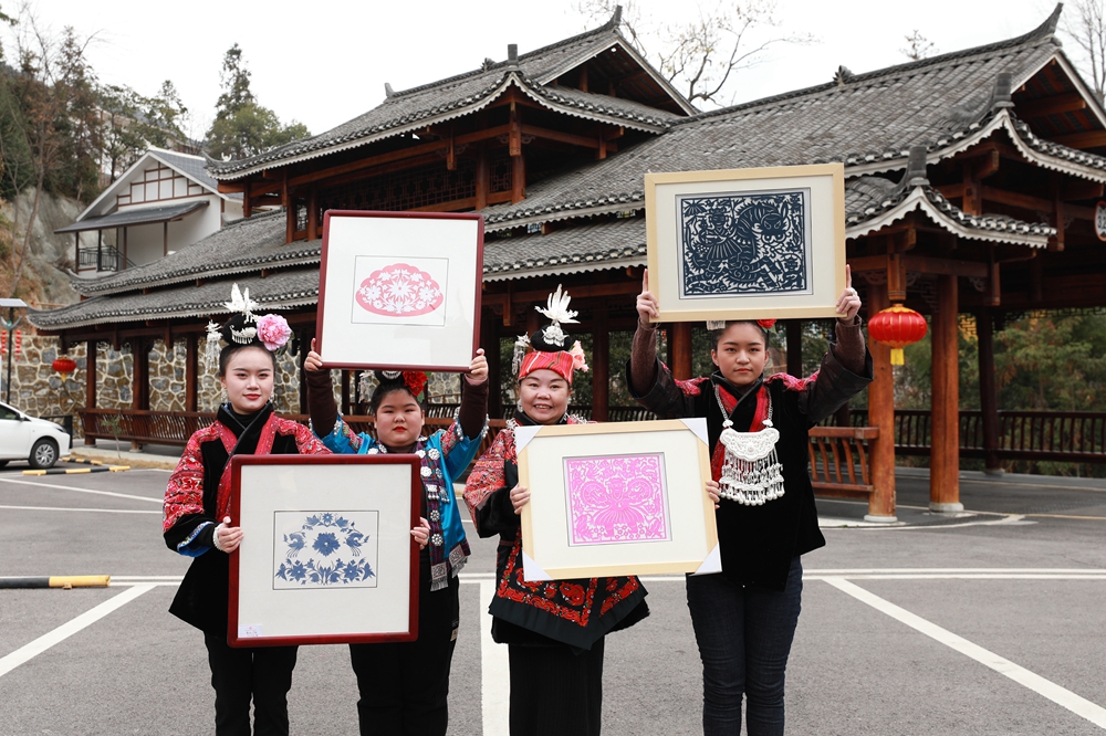 贵州剑河：生肖剪纸贺新年_fororder_1月17日，国家级非物质文化遗产苗族剪纸传承人姜文英（右二）和剪纸爱好者在剑河县华润希望小镇展示剪纸作品。（杨家孟 摄）.JPG