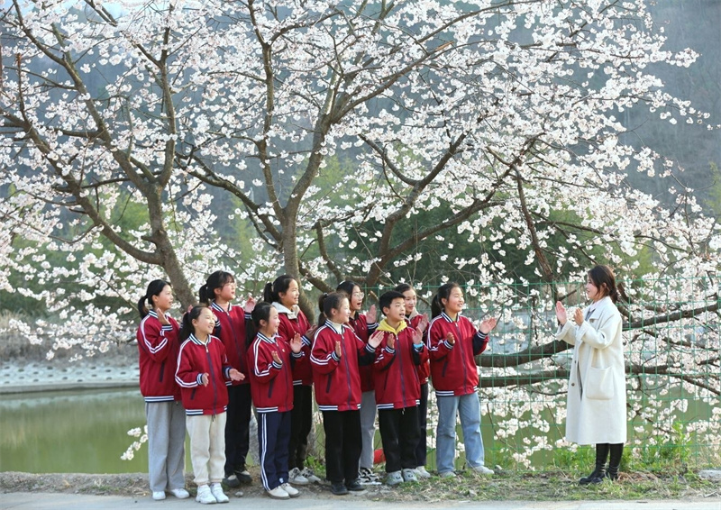 【春日“豫”新景】信阳商城：山花烂漫迎春来_fororder_学生假日春游，桃花树下传笑语。游家明 摄 - 复件(1)