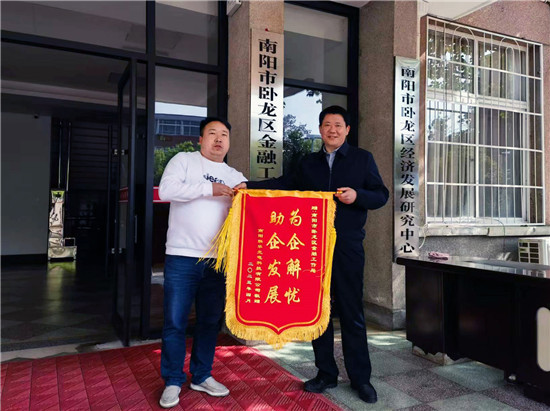 南阳市卧龙区：金融“活水”助企纾困解难_fororder_南阳联华光电科技有限公司总经理华林冲（左一）向卧龙区金融工作服务中心赠送锦旗 摄影 夏倩