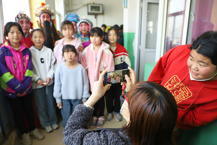 图片默认标题_fororder_学生们在课间休息时争相跟剧团演员合影。熊华明摄