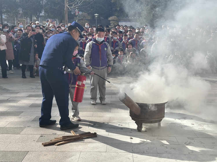 图片默认标题_fororder_满城区消防大队队员现场指导孩子灭火方法。刘朋 摄