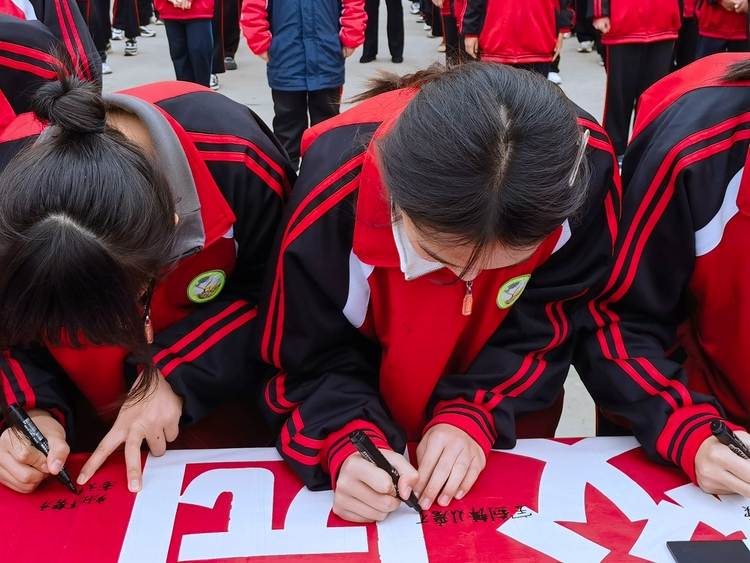 图片默认标题_fororder_要庄中学同学们在条幅上签名 摄影 杨峰