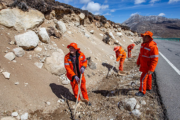 （张）达登拉山养护管理站：雪域高原的“铺路石” 畅通甘孜现代化的开放通道_fororder_养路工人清理沟渠-摄影李永杰