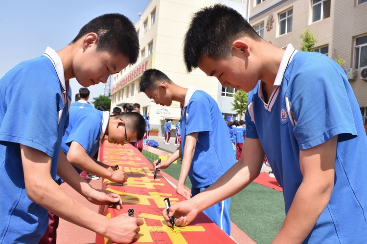 （原创）河北清苑：织密中小学生“防溺水”安全防护网_fororder_同学们在防溺水宣传横幅上签名。 赵琪摄.JPG