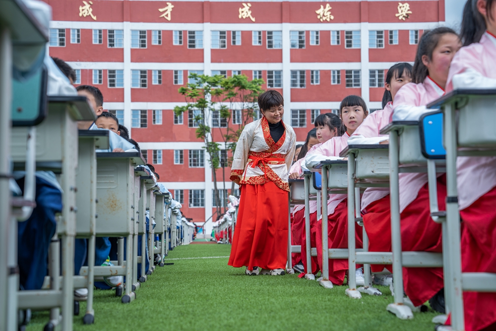 贵州毕节：诵“国学” 展“国韵”_fororder_2023年5月12日，学生们在贵州省毕节梁才学校操场上参加书写汉字古文活动。  (4)