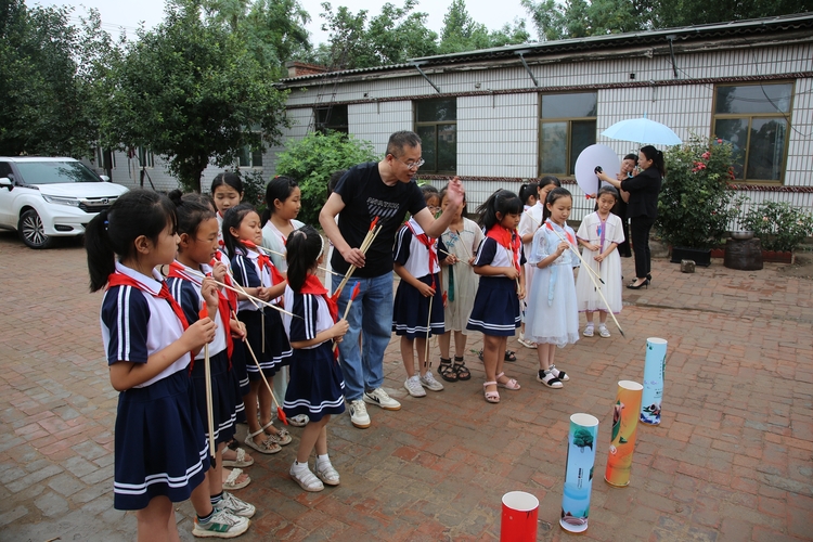 图片默认标题_fororder_教师为学生示范投壶游戏 摄影 许志坚