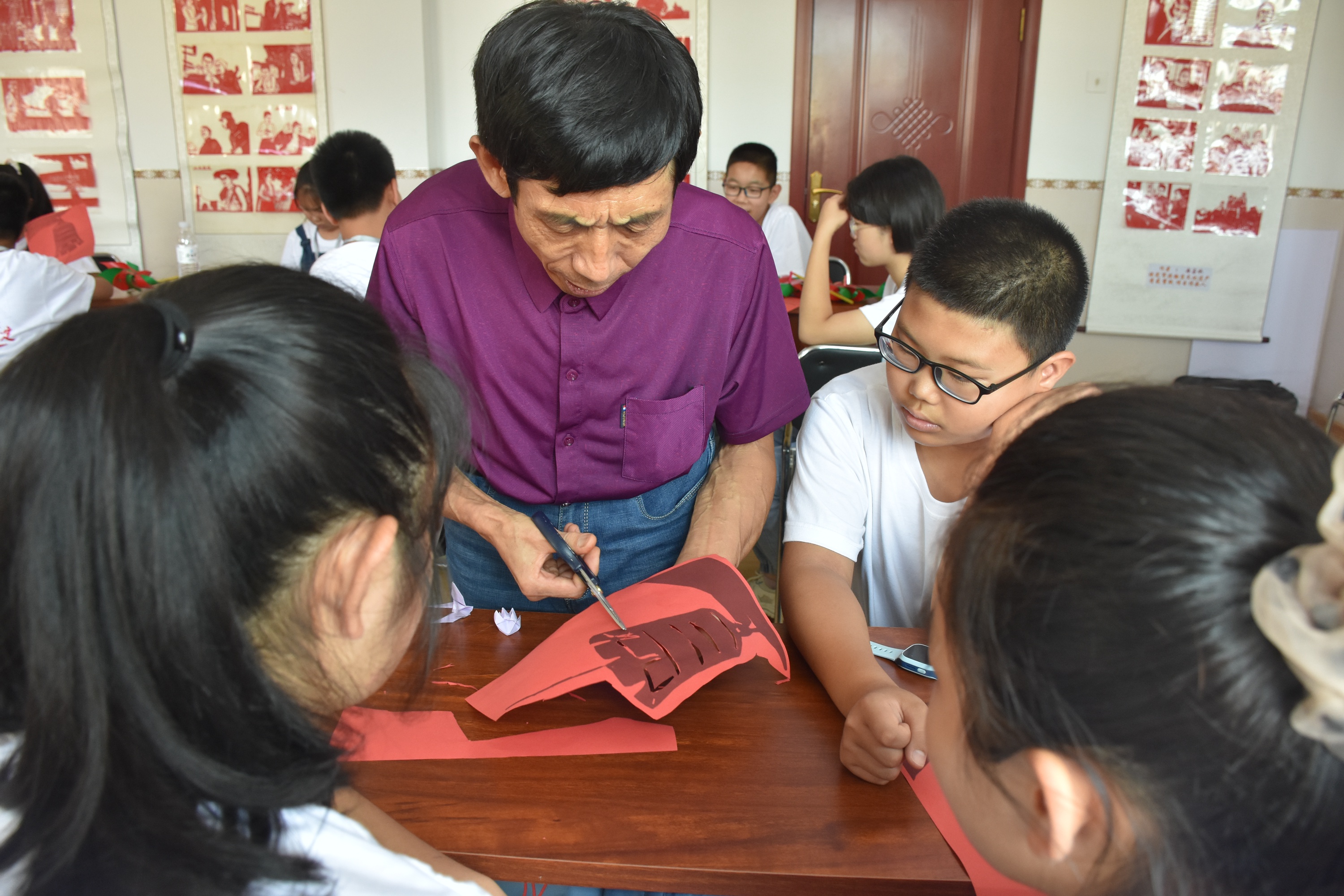 图片默认标题_fororder_清苑曹庄村剪纸非遗传承人冉占水指导中小学生剪纸。刘一诺摄.JPG