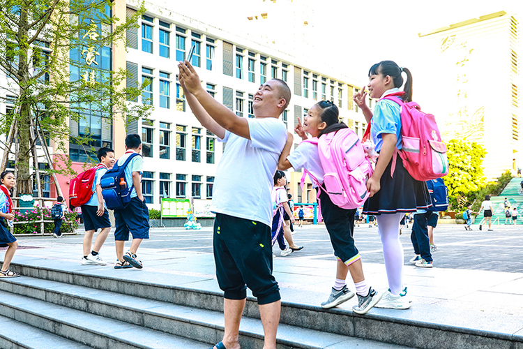 组图｜泸州合江：启航喜迎新学期_fororder_8、9月1日，四川省泸州市合江县人民小学校，一名家长陪同孩子快乐地打卡合影-。