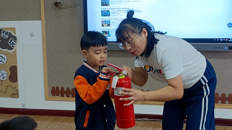 图片默认标题_fororder_老师教孩子们认识和使用灭火器