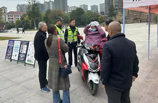 眉山青神：交警送头盔 把安全“戴”回家_fororder_交警向群众宣传骑车佩戴头盔-供图-青神县委宣传部