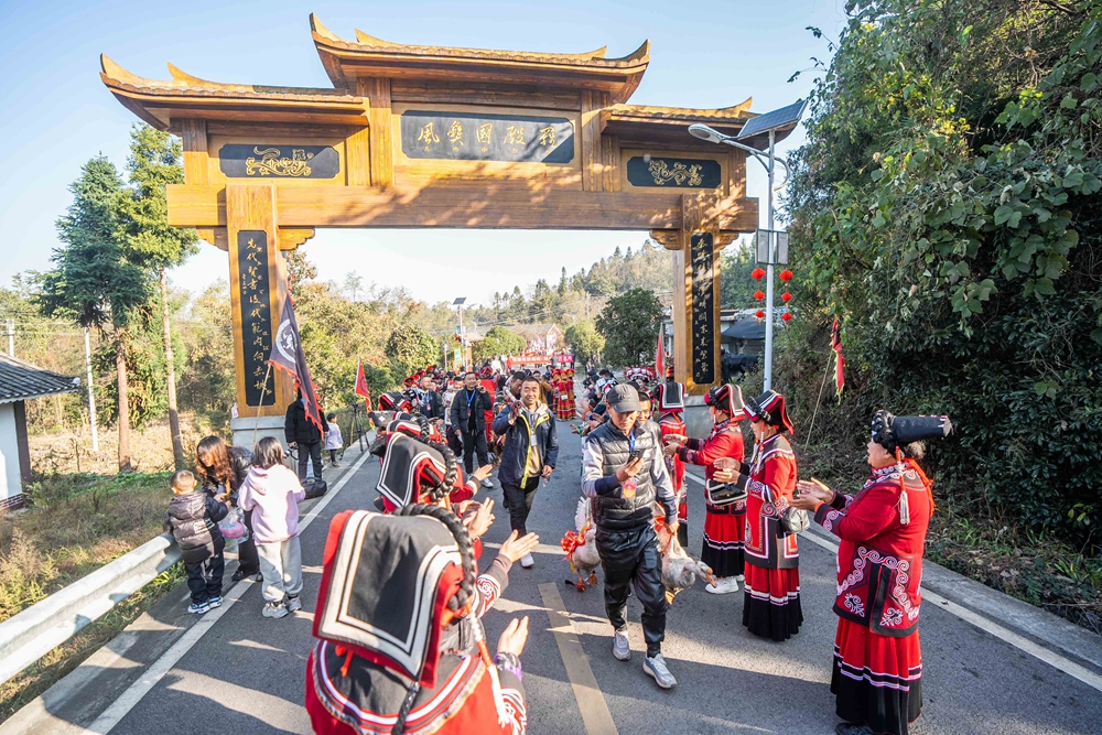 贵州毕节：乡邻一家亲 共庆彝族年_fororder_2023年11月19日，在贵州省毕节市百里杜鹃管理区普底乡迎丰村，前来参加彝族年的群众排队进村。 (1)