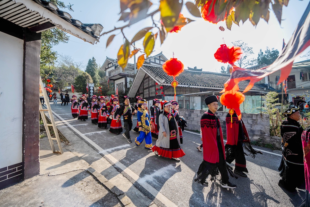 贵州毕节：乡邻一家亲 共庆彝族年_fororder_2023年11月19日，在贵州省毕节市百里杜鹃管理区普底乡迎丰村，前来参加彝族年的群众排队进村。 (2)