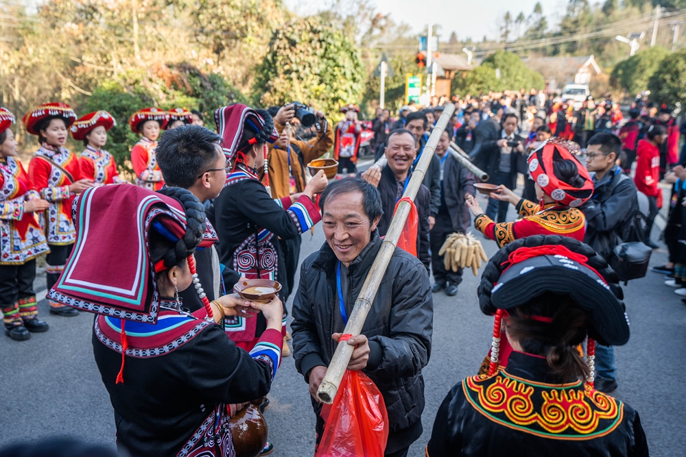 贵州毕节：乡邻一家亲 共庆彝族年_fororder_2023年11月19日，村民在贵州省毕节市百里杜鹃管理区普底乡迎丰村为前来参加彝族年的嘉宾送上拦门酒。 (4)