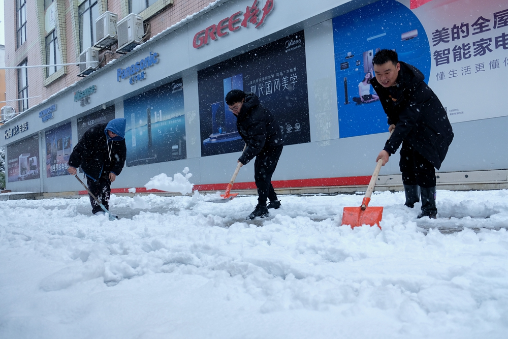 贵州天柱：干群齐心 除雪保安全_fororder_县融媒体中心干部职工在县文体广电旅游局门口扫除积雪。.JPG