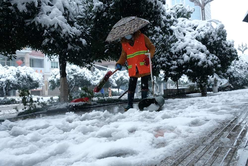 贵州天柱：干群齐心 除雪保安全_fororder_清洁工人在贵州银行门口清扫积雪。.JPG