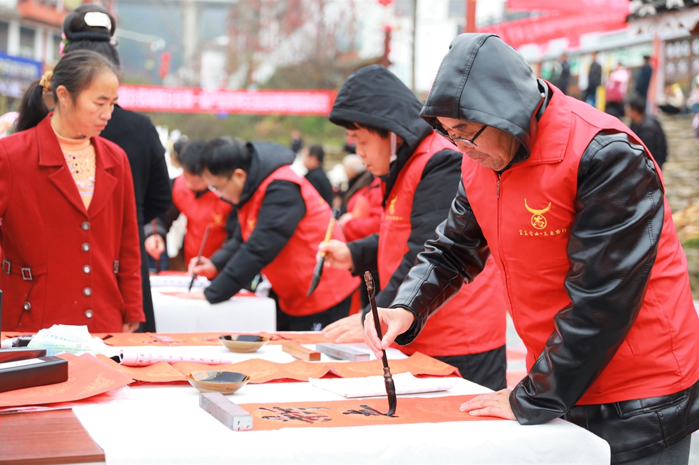 贵州雷山：写春联迎新春_fororder_2023年2月2日，在贵州省黔东南苗族侗族自治州雷山县龙头街道移民安置点，书法志愿者为居民义务写春联。 (3)