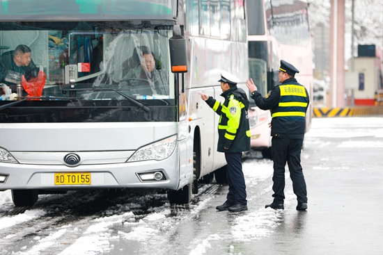 贵州天柱：警车雪中护航 温暖群众回家路_fororder_交警在指挥车辆.JPG