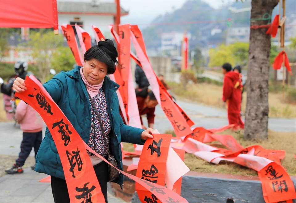 贵州雷山：写春联迎新春_fororder_2023年2月2日，在贵州省黔东南苗族侗族自治州雷山县龙头街道移民安置点，居民在挑选春联