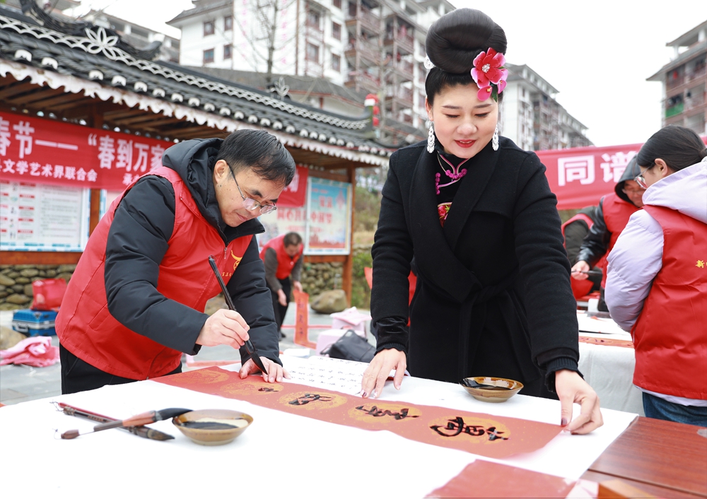 贵州雷山：写春联迎新春_fororder_2023年2月2日，在贵州省黔东南苗族侗族自治州雷山县龙头街道移民安置点，书法志愿者为居民义务写春联。 (4)