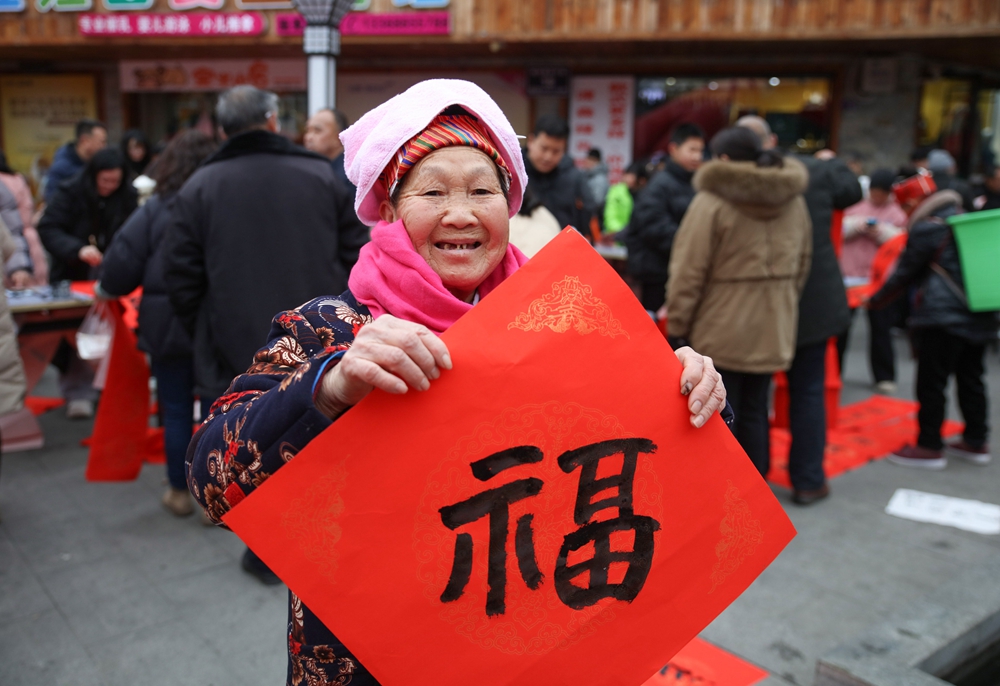 贵州施秉：春节近 年味浓_fororder_2024年 2月5日，市民在贵州省黔东南苗族侗族自治州施秉县城步行街展示书法爱好者书写的福字。（磨桂宾 摄）.JPG