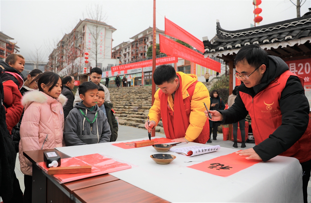 贵州雷山：写春联迎新春_fororder_2023年2月2日，在贵州省黔东南苗族侗族自治州雷山县龙头街道移民安置点，书法志愿者为居民义务写春联。 (1)