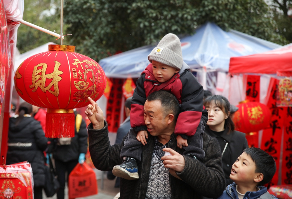 贵州施秉：春节近 年味浓_fororder_2024年2月5日，市民在贵州省黔东南苗族侗族自治州施秉县城年货集市上选购新春饰品。（磨桂宾 摄） (5).JPG