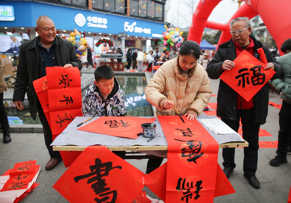 贵州施秉：春节近 年味浓_fororder_2024年2月5日，书法爱好者在贵州省黔东南苗族侗族自治州施秉县城步行街为群众书写春联。（磨桂宾 摄） (2).JPG