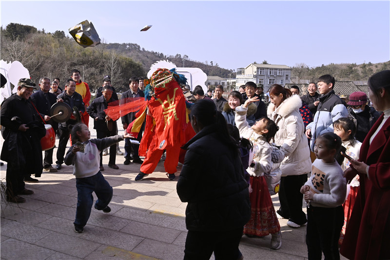 信阳新县：欢天喜地闹新春_fororder_小朋友与舞狮表演互动（焦汉平 摄）