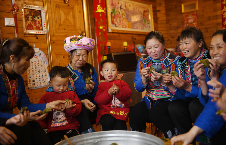 广西龙胜：春日瑶寨艾粑香  不负美食不负春_fororder_3月15日，在广西桂林市龙胜各族自治县江底乡江底村，瑶族村民围坐在一起品尝艾粑。 (1)